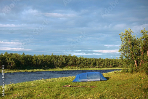 Large blue tent by the river on sunny day in Swedish Lapland at end of July 2022.