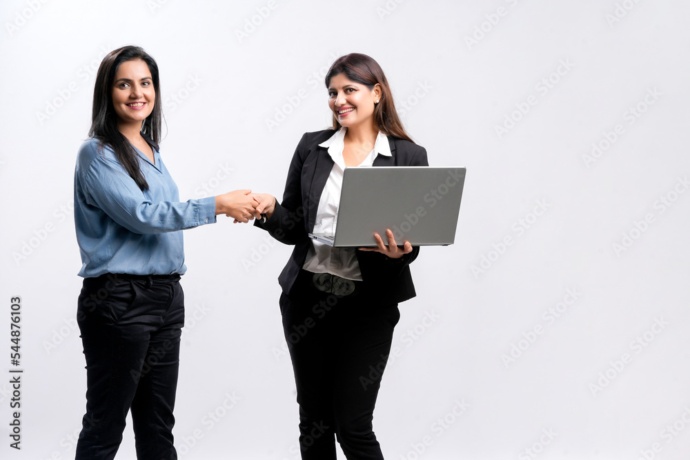 Two indian Businesswomen Shaking Hands on white background. Two indian Businesswomen Shaking Hands on white background.