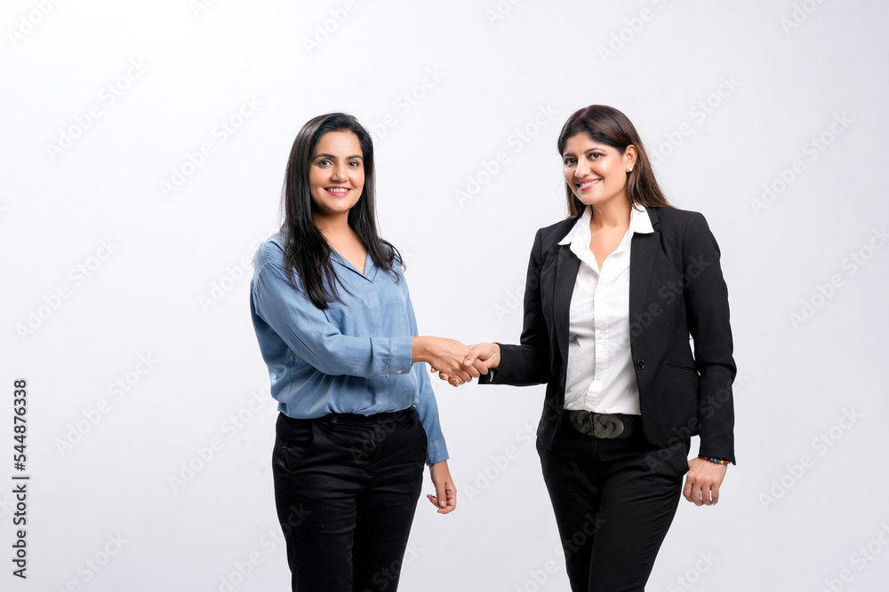 Two indian Businesswomen Shaking Hands on white background.