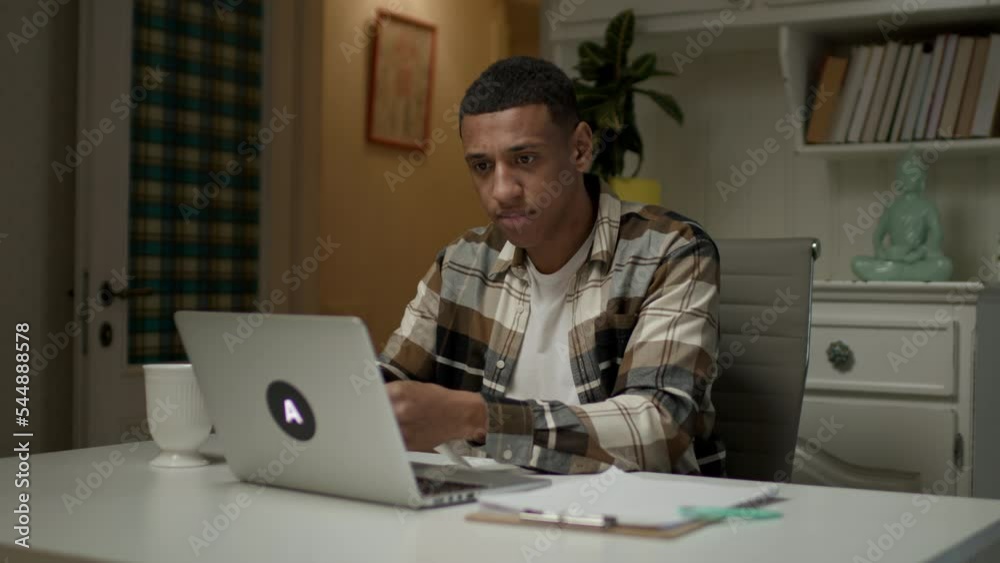 Man accounting expenses. Lots of receipts falling on African American man using laptop. Man accounting expenses. Lots of receipts falling on African American man using laptop.