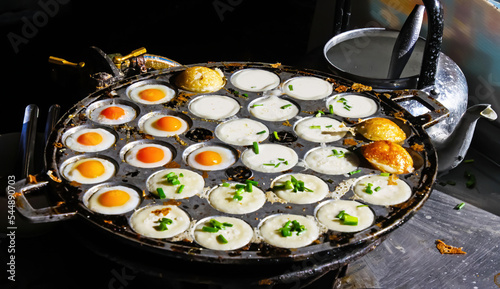 Traditional thai street food breakfast snack with fried quail eggs (Khai Nok Gatta) , coconut pudding pancakes (Kanom Krok) in takoyaki pan - Thailand