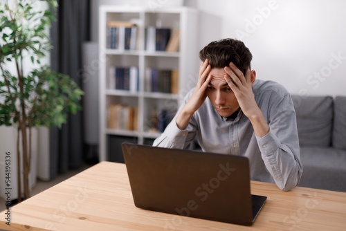 Frustrated man looking on laptop