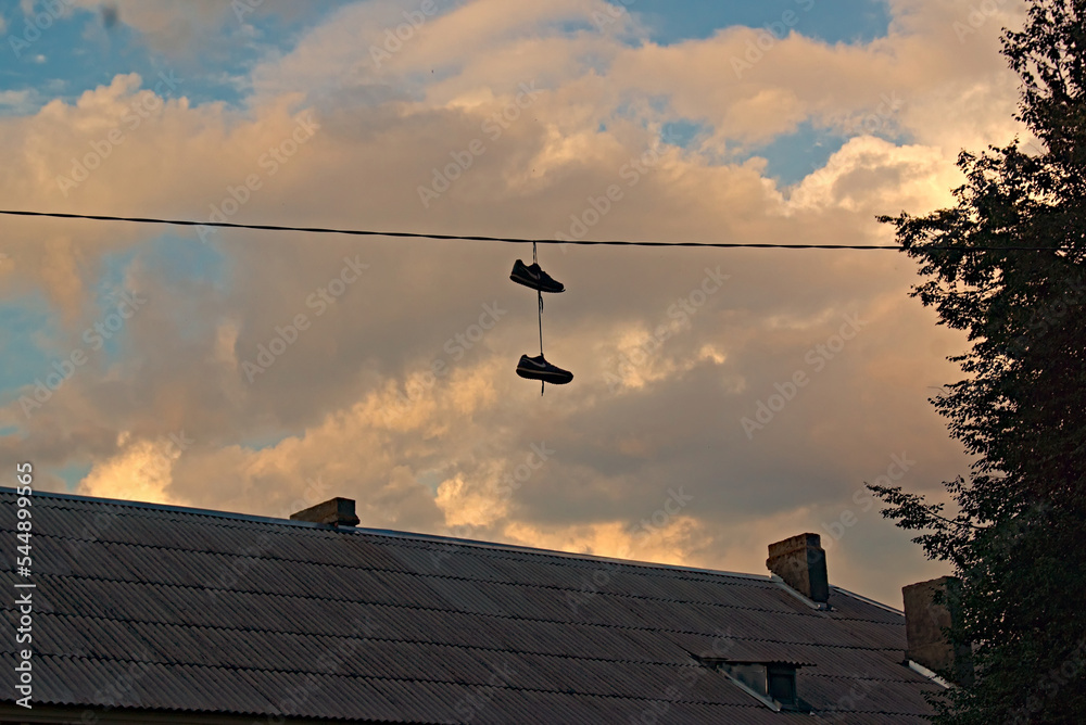 boots, with tied laces, hanging from the wires of a power line boots, with tied laces, hanging from the wires of a power line