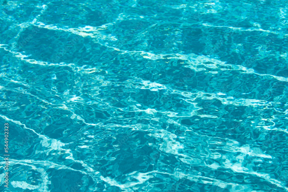 Background of blue water in swimming pool with sun reflection, ripple water wave in pool. Clear water background. Background of blue water in swimming pool with sun reflection, ripple water wave in pool. Clear water background.