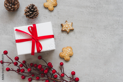 Eine weiße Geschenk Box mit roter Schleife und Lebkuchen Kekse auf einem grauen Tisch. Weihnachten.