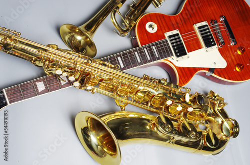 Electric guitar, trumpet and golden saxophone on a light background.