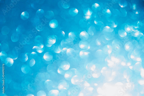 Shiny light blue blurred background for holiday design. Christmas abstract textured glitter, selective focus