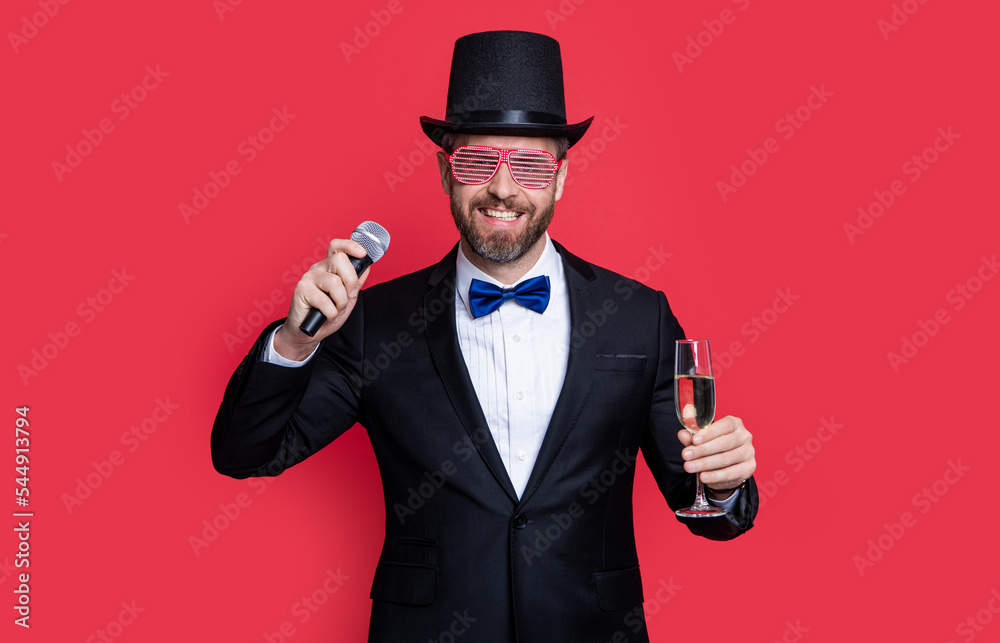 Naklejka premium magician man cheering with microphone. man magician wear tuxedo in studio.