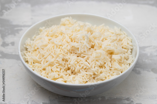Boiled rice in a bowl on gray background.