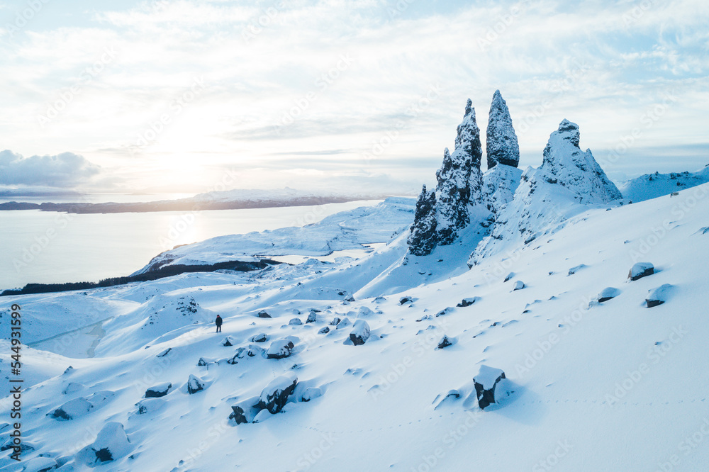 Old Man of Storr in the snow, Isle Of Skye. Person hiking in snow up ...