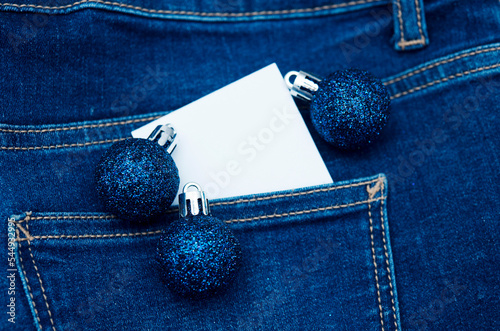 Christmas blue balls with white card copy space over jeans denin pocket like jolly young Christmas graphic background  photo