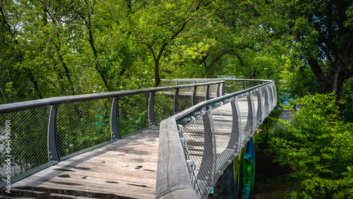 Fotografie Parkview Tree Canopy Trail curving wood bridge riverfront walkway in Promenade Park over the St