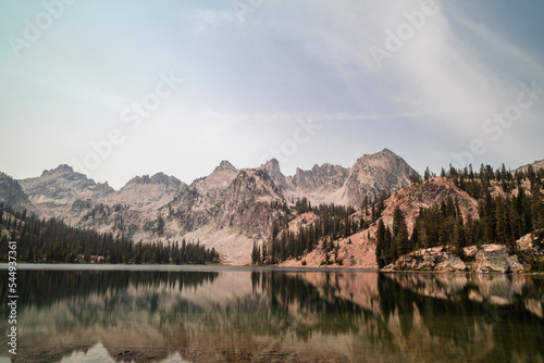 Alice Lake, a large alpine lake in Idaho’s Sawtooth Mountains seen on a summer day. The lake is within the Sawtooth Wilderness and Sawtooth National Forest and is a popular hiking destination.