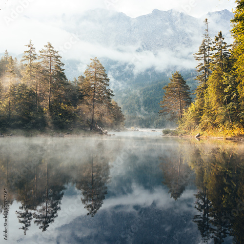 Beautiful misty morning on Eibsee, Oberammergau. Bavaria, Germany. Zugspitze Mountain in background 