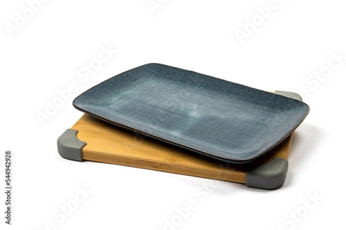rectangular ceramic plate of dark blue color standing on a bamboo board with gray design elements on a white background