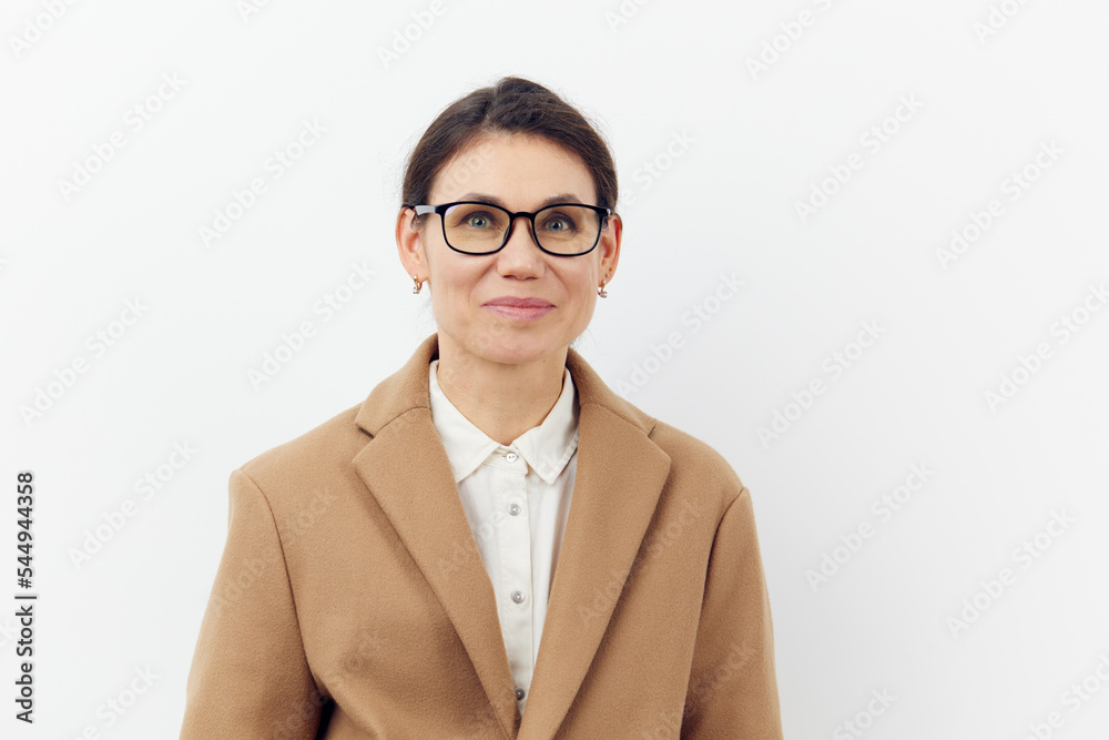 portrait of a beautiful attractive woman in stylish glasses and a beige raincoat on a light background with an empty space for an advertising layout portrait of a beautiful attractive woman in stylish glasses and a beige raincoat on a light background with an empty space for an advertising layout