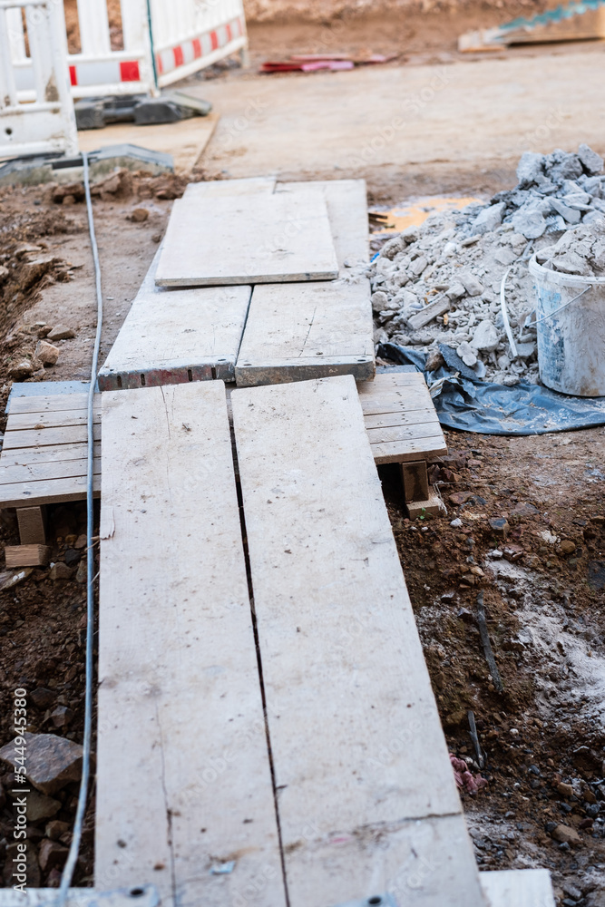 Planken über einem Graben auf einer Baustelle