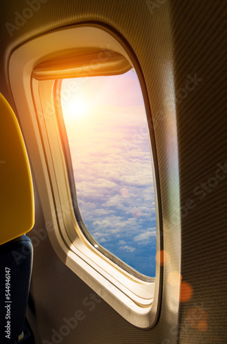 Soleil couchant à travers le hublot d'un avion.