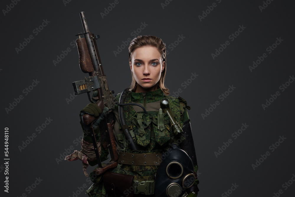 Portrait of apocalyptic female survivor holding rifle dressed in camouflage uniform. Portrait of apocalyptic female survivor holding rifle dressed in camouflage uniform.