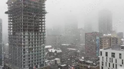 Building under construction in heavy snowfall during winter day
