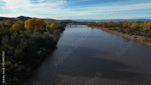 Aerial above Colorado River in Grand Junction, Colorado in autumn lined with beautiful yellow aspen trees photo