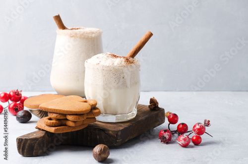 Egg nog Christmas drink on a brown background with gingerbread.