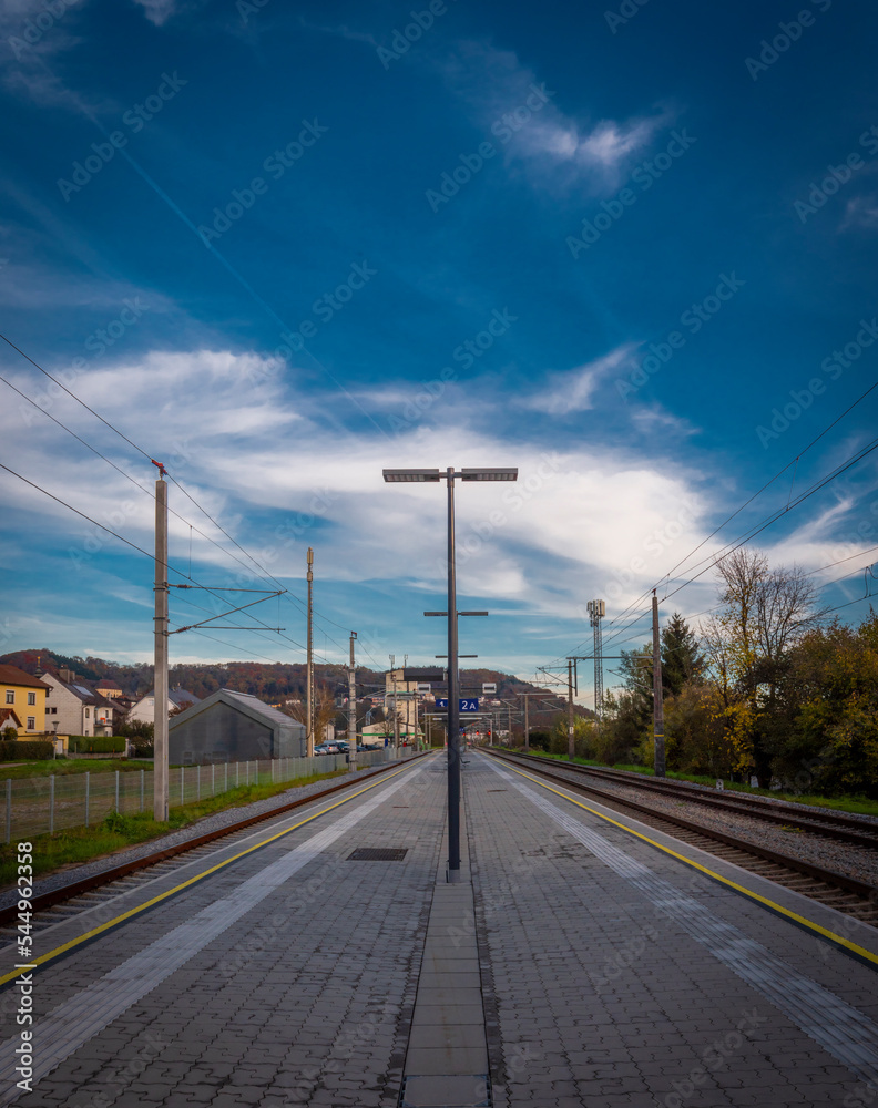 Steyregg station with dark blue sky and platform in autumn evening