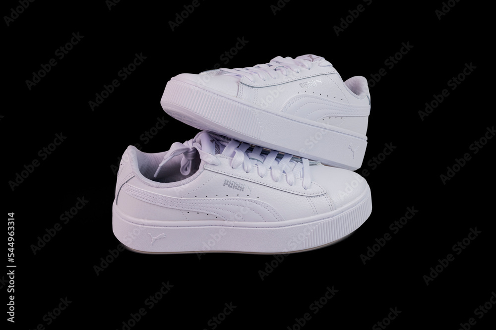 Close up view of white Puma sneakers isolated on black background. Sweden.  Stock Photo | Adobe Stock