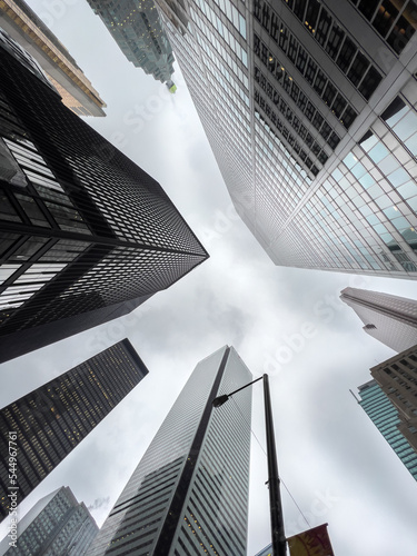 Low angle view of office buildings in city with cloudy sky in background photo