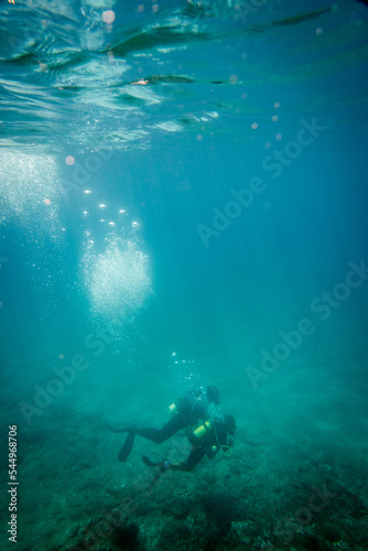 Boy scuba diving with father in sea