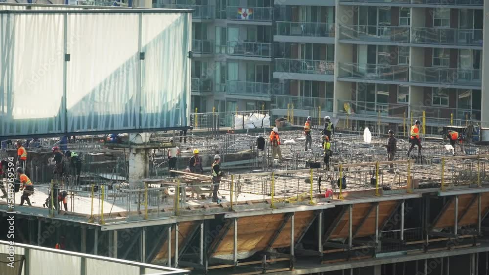 Workers at top of building at construction site Workers at top of building at construction site