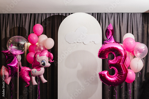 Birthday party decorated with pink, violet balloons in the style unicorn, rainbow, my little pony. Idea for decorating party. Reception. Copy space. Birthday arch for 3 years and a photo wall. photo