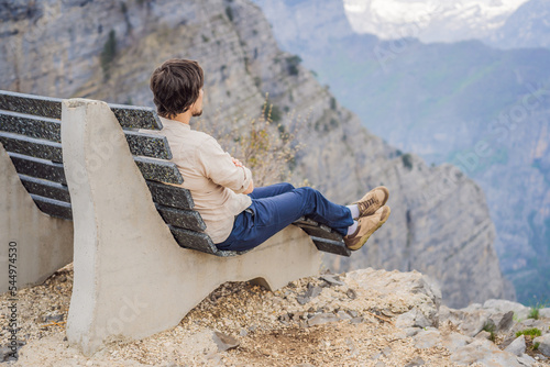 Man tourist on background of Breathtaking panoramic view of the Grlo Sokolovo gorge in Montenegro. In the foreground is a mountain, the flat side of which forms a cliff, and the ridge is overgrown photo