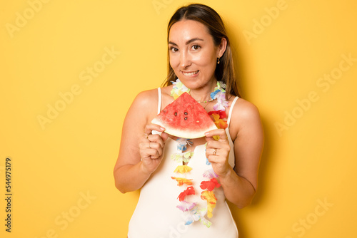 young pretty women holding a slice of watermelon in hands and smiling happy  summertime concept and mood  over yellow background