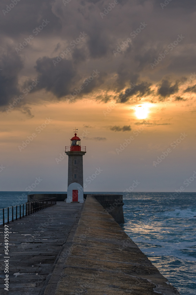 Lighthouse on the storm sea under sunset sky. Porto, Portugal