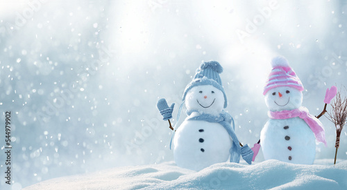 Merry Christmas and happy New Year greeting card with copy-space. Snow background. Winter fairytale. Two cheerful friends snowmen holding hands