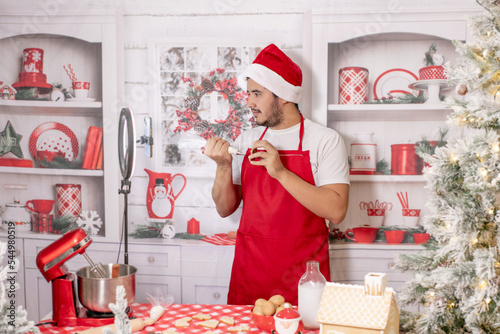 hombre alegre caucásico, haciendo y decorando galletas navideñas para celebrar la navidad en familia