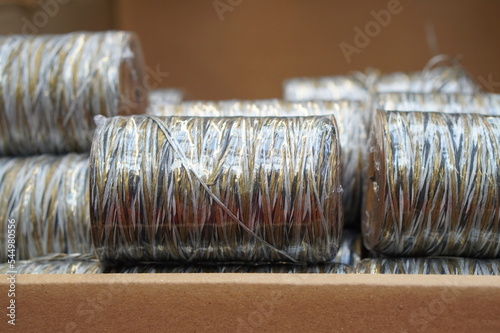 Billede på lærred a reel with decorative threads of melange gold with silver and white flowers, pa