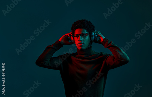 Portrait of man put on headphones over dark © Nomad_Soul