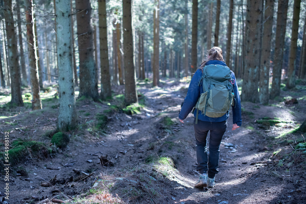 Frau mit Rucksack wandert durch einen Wald im Sauerland