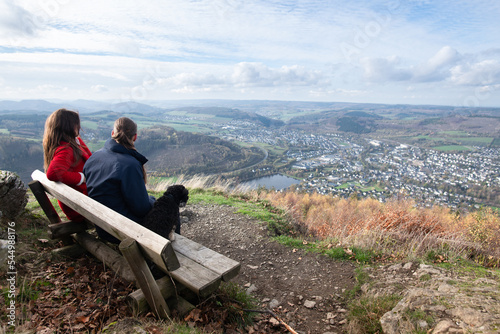 Freundinnen genießen nach der Wanderung, vom Gipfel des Berges, die atemberaubende Aussicht der Landschaft im Sauerland photo