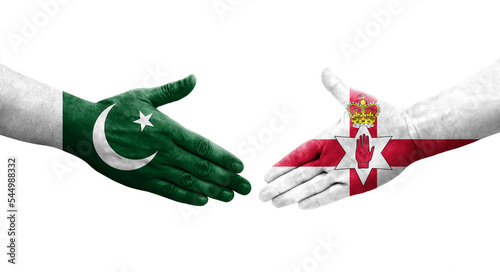 Handshake between Northern Ireland and Pakistan flags painted on hands, isolated transparent image. photo