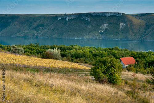 House with red roof on the slopes of the Dniester. The flooded village of Bak...