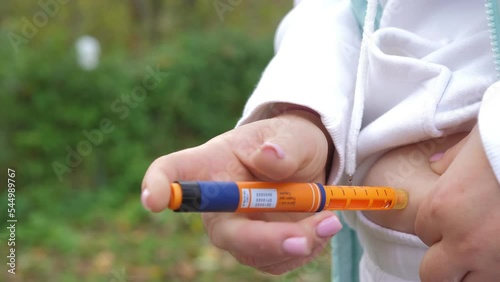Woman diabetic using insulin pen for injecting insulin at home. Diabetes control. Close-up of a woman makes a shot of insulin in the fat fold on the stomach. Diabetic glycemic control, vaccination.