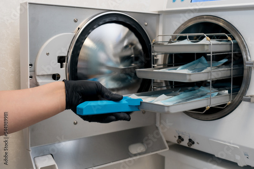 sterilizing medical instruments in autoclave, cropped shot