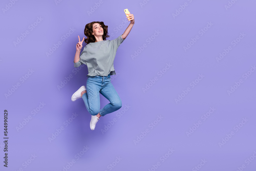 Full length photo of positive blogger chatting facebook instagram followers v-sign empty space isolated on purple color background