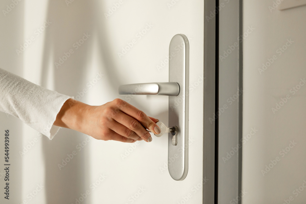 The hand puts the key in the keyhole and opens the door The hand puts the key in the keyhole and opens the door