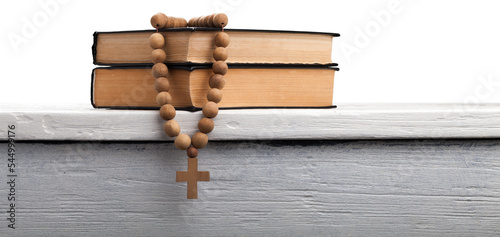 The book of Catholic and rosary beads on the wooden table photo