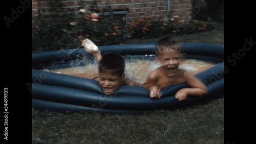 Playing in the Kiddie Pool 1954 - Two brothers splash in a kiddie pool in their suburban Chicago home in 1954. 