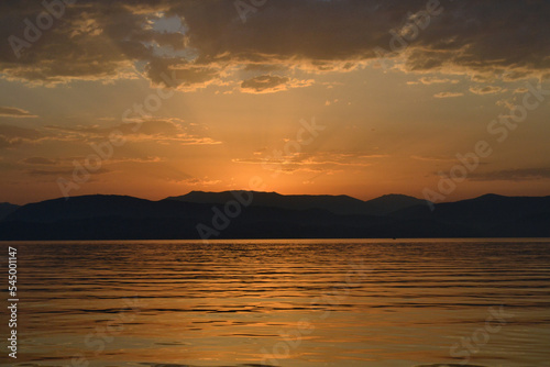 Sun is rising from the mountains in Ionian sea. © OlgaMaria